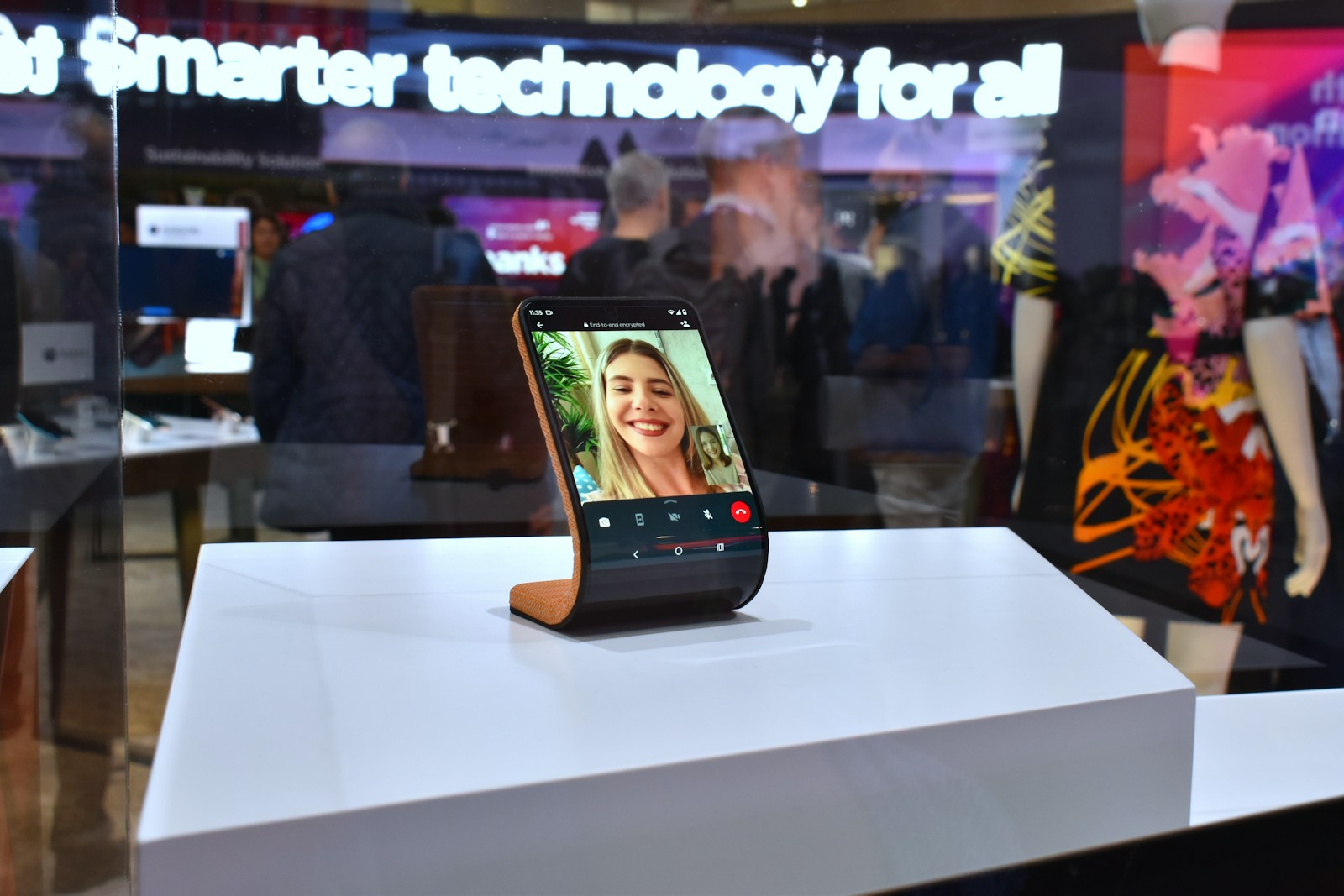Smartphone displaying a video call on a stand.