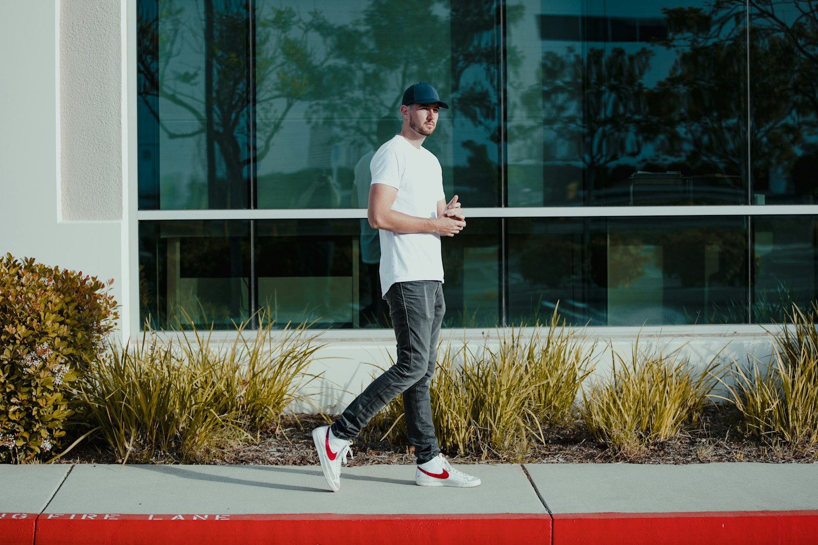 a man walking down a sidewalk in front of a building