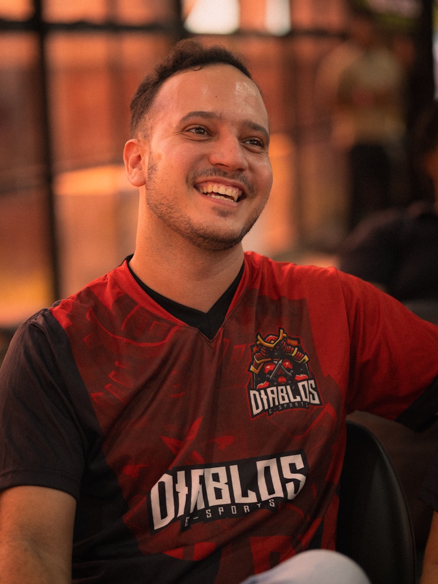 Man in red and black esports jersey smiling
