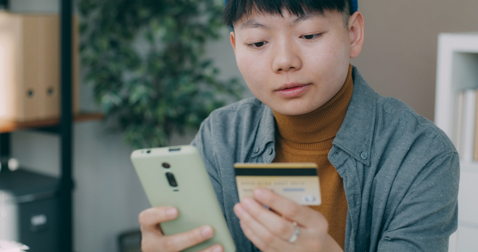A man sitting at a table looking at a cell phone