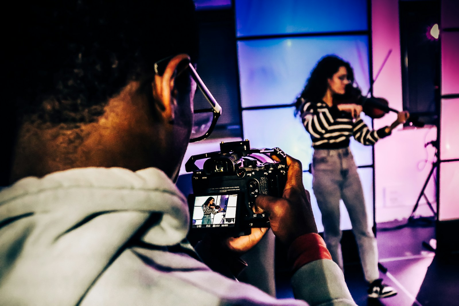 a woman holding a camera in front of a man